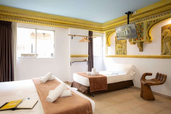 una habitación con dos camas y una silla en forma de mano