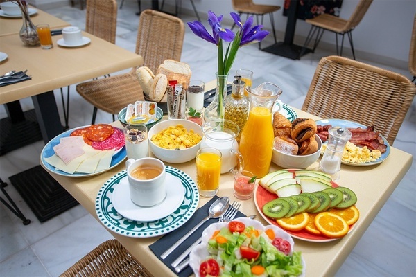a table topped with plates of food and a pitcher of orange juice