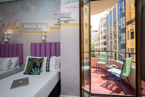 una habitación con una cama y una puerta que da a un balcón