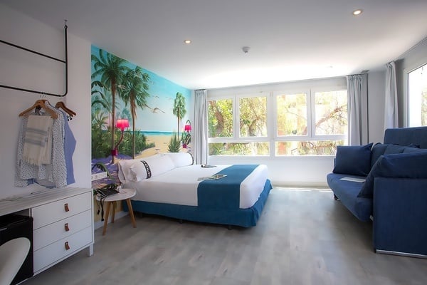 una habitación de hotel con una cama king size y un sofá azul