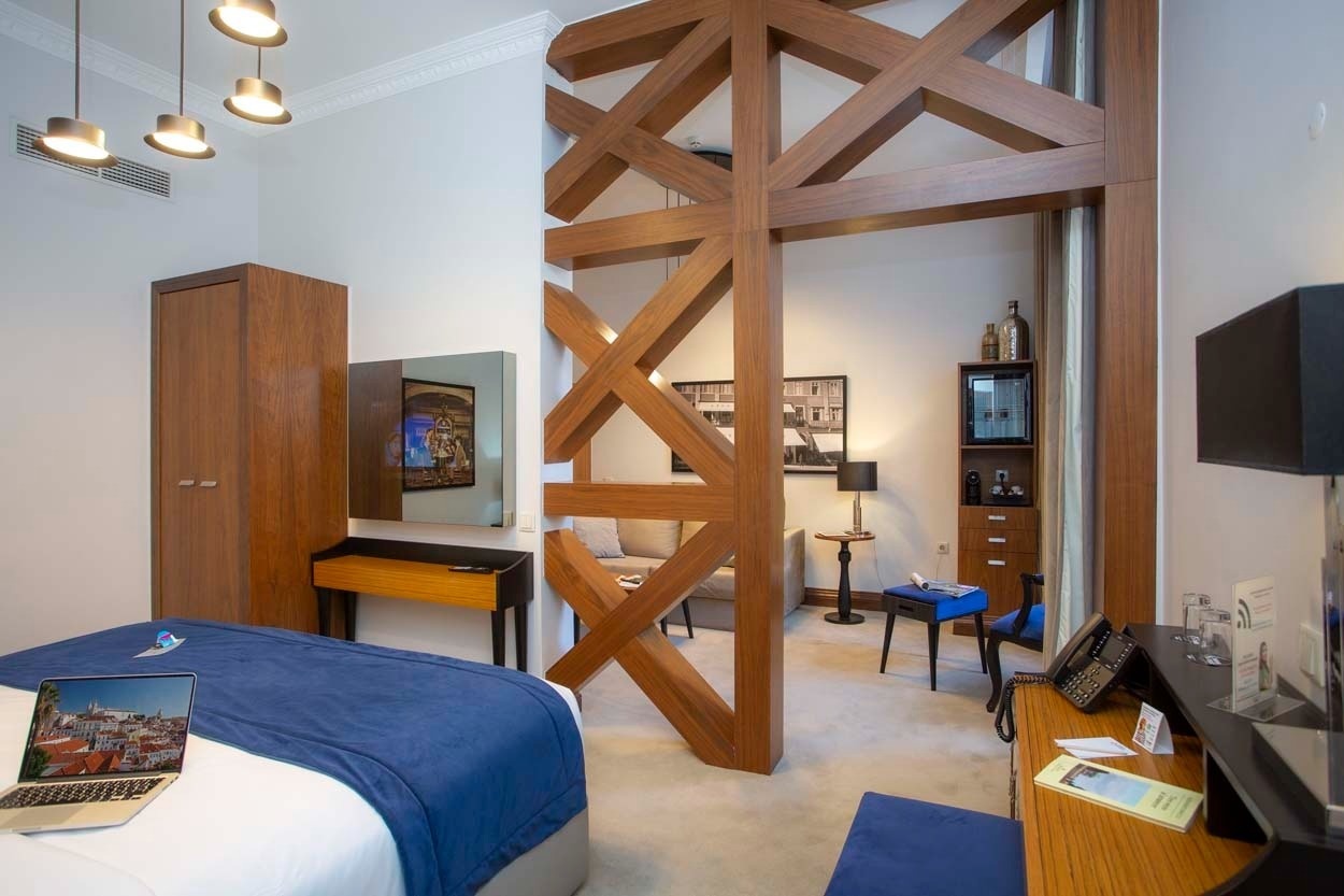 Geräumiges Zimmer im Casual Belle Époque - Boutique-Hotel in Lissabon mit stilvoller Holzverkleidung.