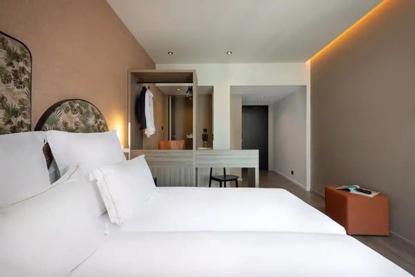 een hotelkamer met twee bedden en een bureau