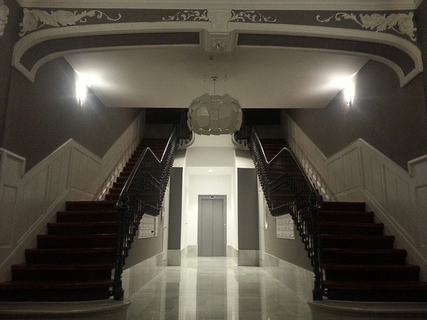 a hallway with stairs leading up to an elevator