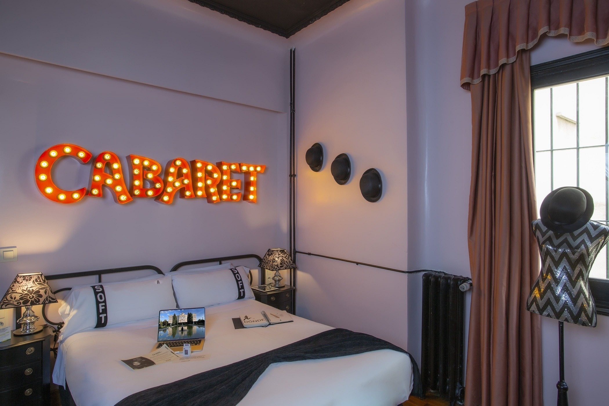 a bedroom with a cabaret sign above the bed