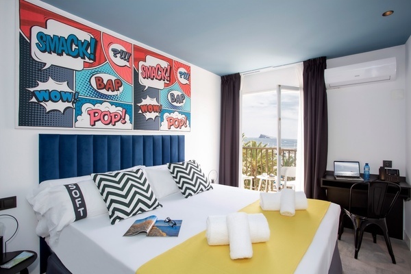una habitación de hotel con una cama y un escritorio
