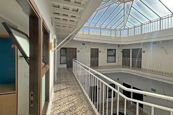 a hallway with a green exit sign on the wall
