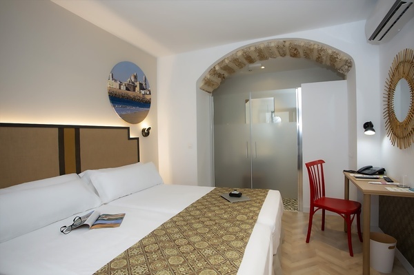 a hotel room with a bed a desk and a chair