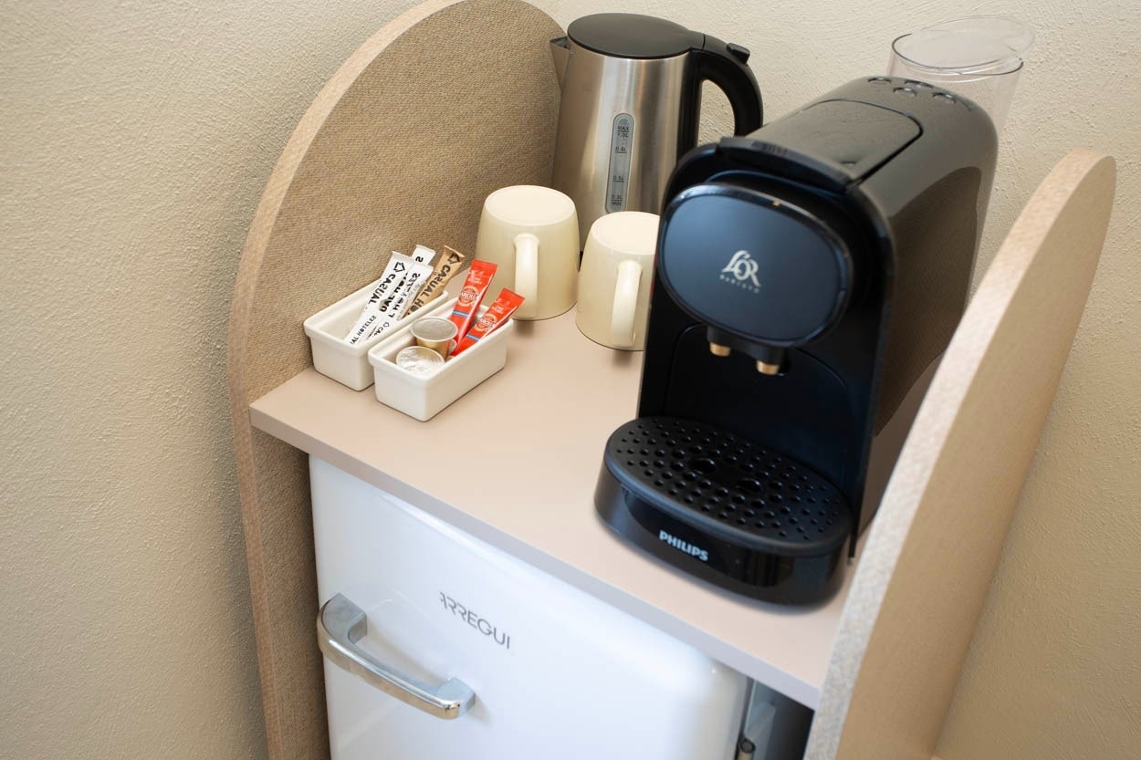 Machine à café et mini-frigo dans une chambre de l'hôtel Casual Bahía Ibiza.