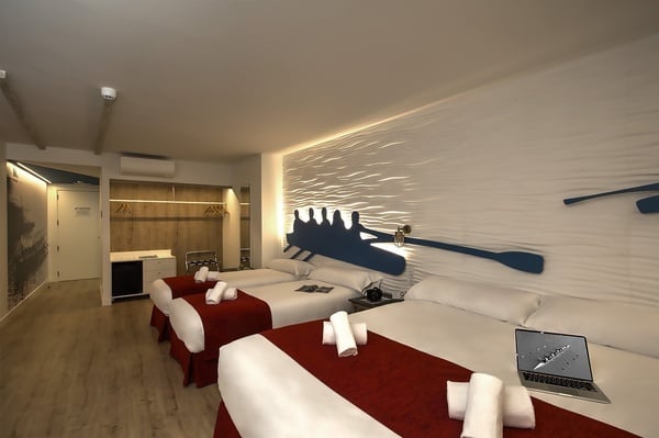 um quarto de hotel com duas camas e um laptop