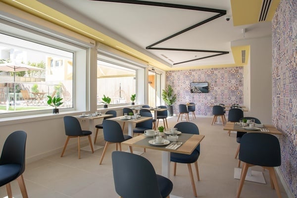 a dining room with blue chairs and white tables