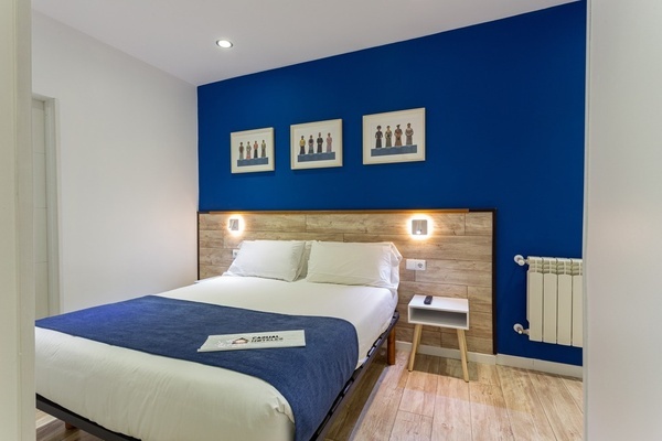 a hotel room with a blue wall and a bed