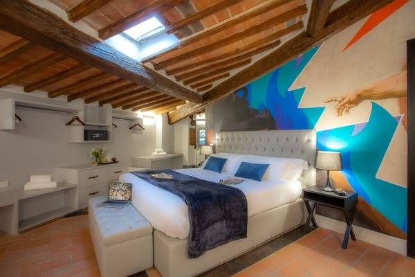 a bedroom with a bed and a painting on the wall