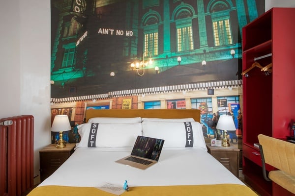 een bed in een hotelkamer met een laptop op het bed