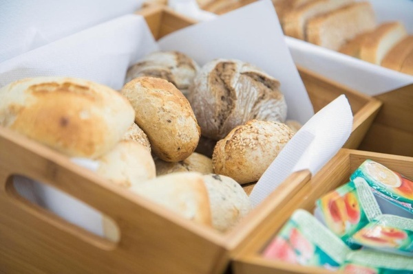 a basket of bread sits next to a box of peach juice