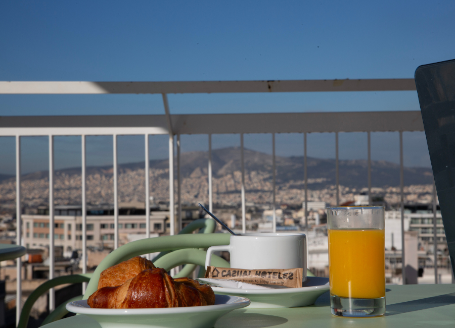 Rooftop breakfast at Casual Hotels with panoramic city and mountain views.