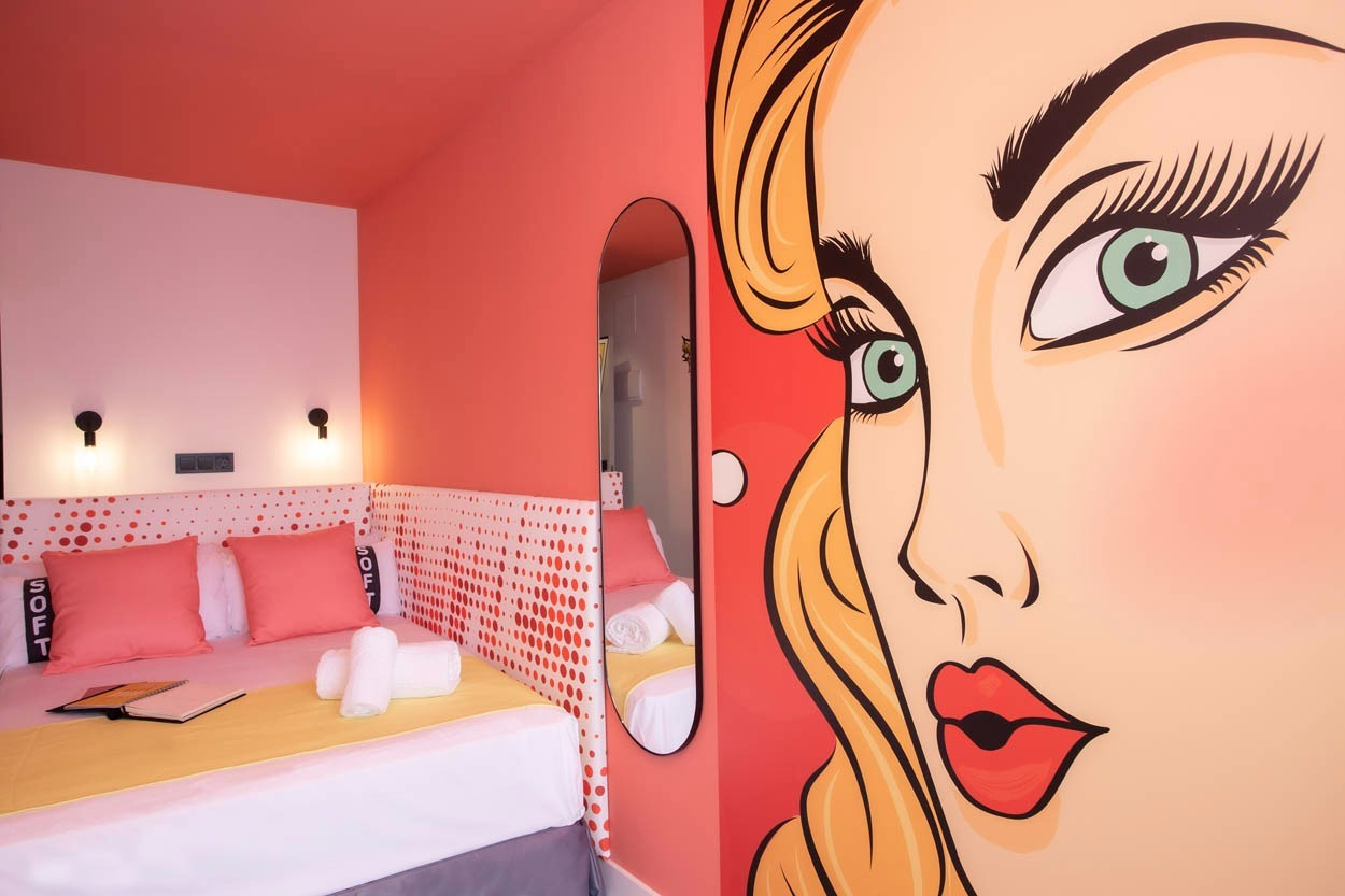 Ein Schlafzimmer im Pop-Art-Stil mit einem Comic-Wandbild, perfekt für einen Aufenthalt im Casual Pop Art Benidorm.