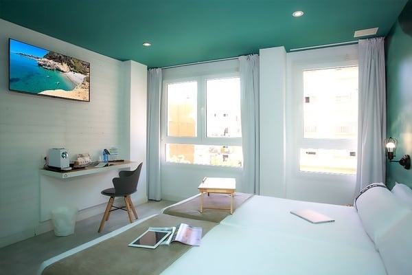 una habitación con una cama y un escritorio con una televisión encima