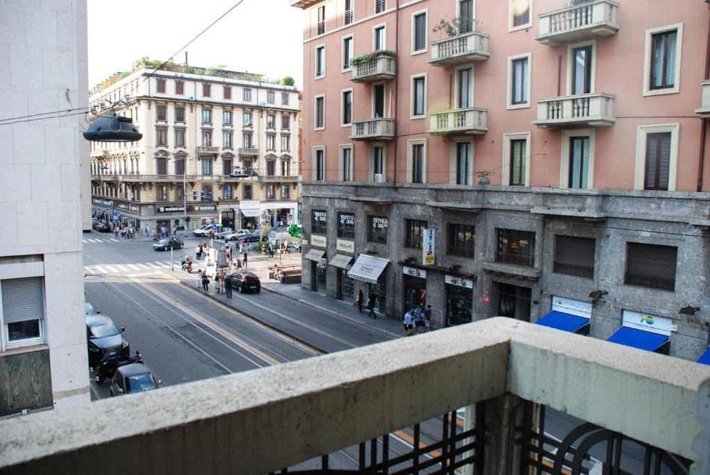 a view of a city street from a balcony with a sign that says ' caffe ' on it