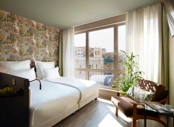 een hotelkamer met twee bedden en een groot raam