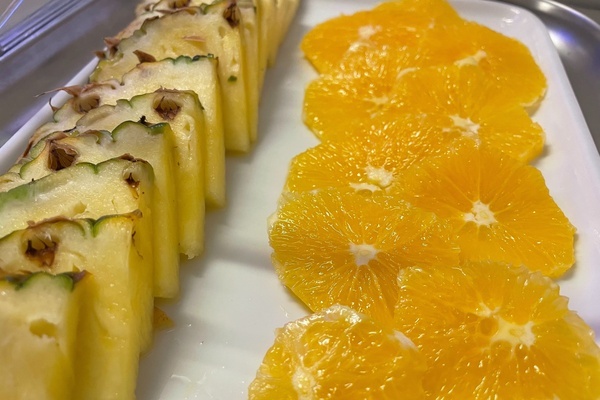 pineapple and orange slices on a white plate