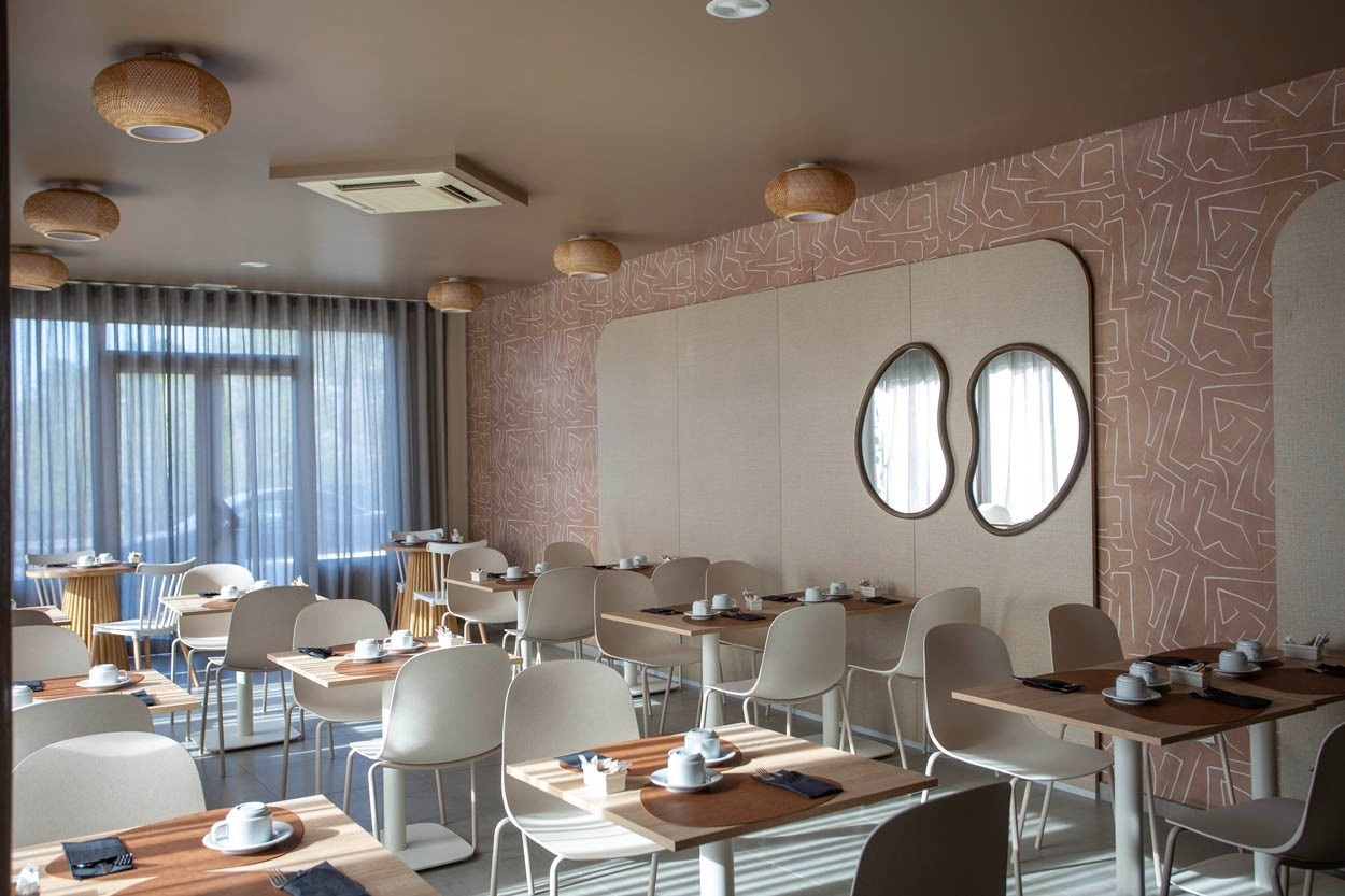 Salle à manger lumineuse du Casual Bahía Ibiza, avec tables dressées et vue sur jardin.