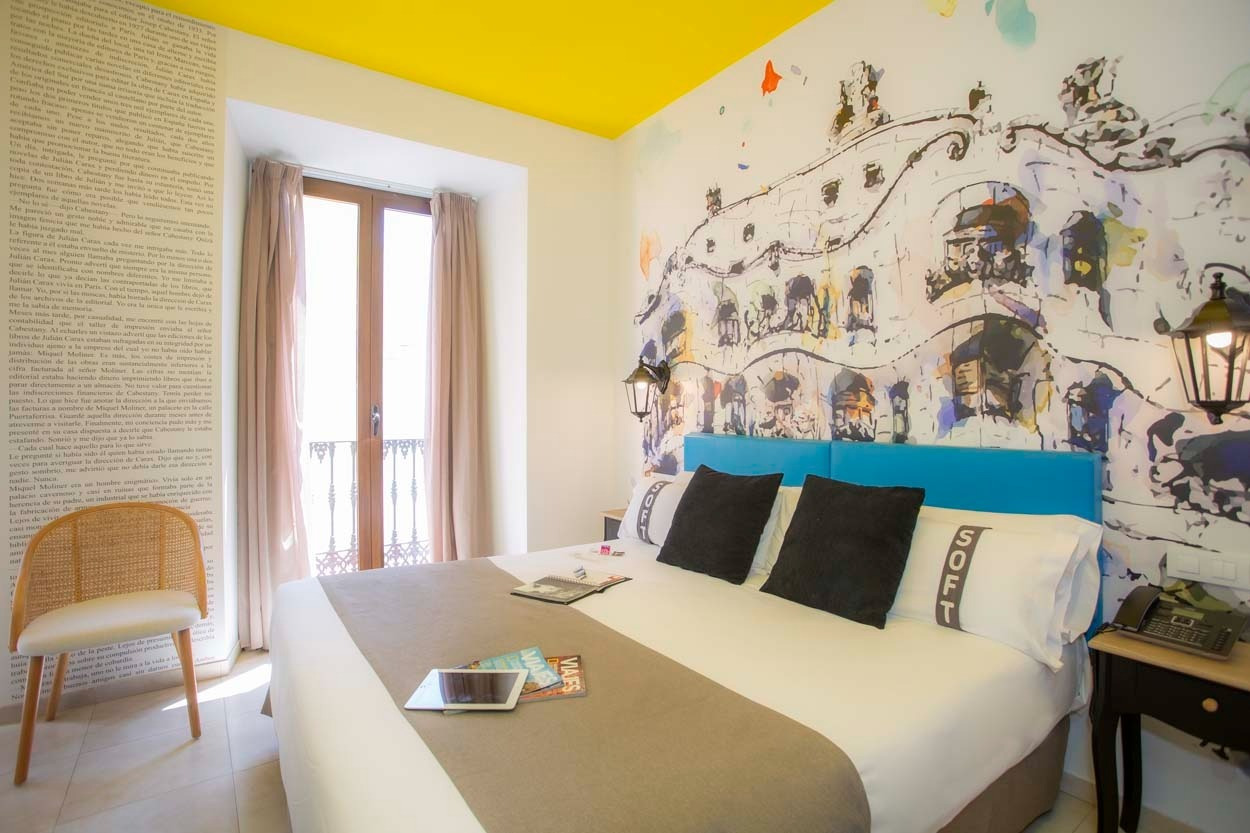 Zimmer im Casual de las Letras Sevilla: Gemütliches Bett mit Kunst an der Wand. Hotel Casual Hoteles.