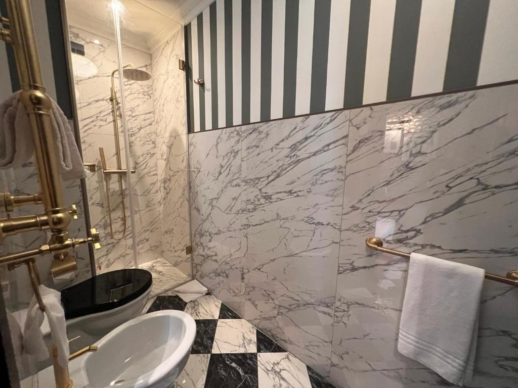 a bathroom with marble walls and a black and white checkered floor