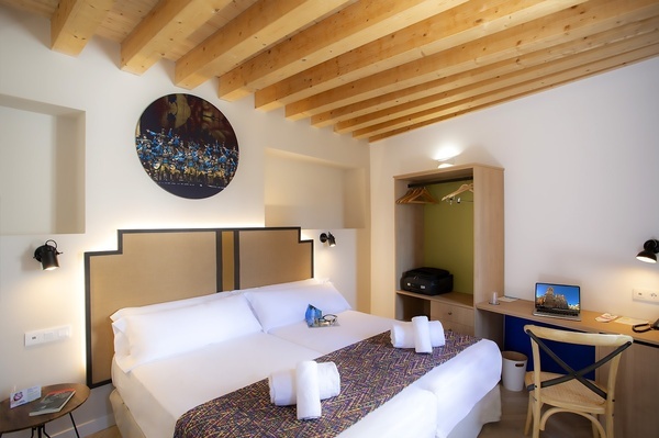 a bedroom with a painting on the wall above the bed