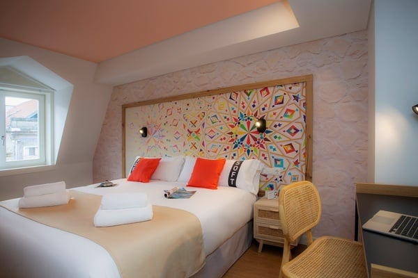 a bed in a hotel room with a colorful headboard
