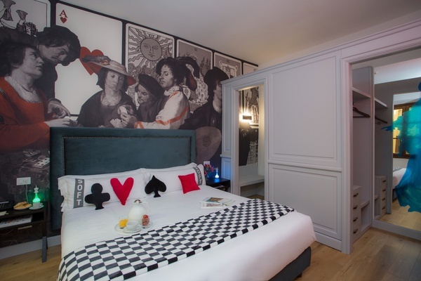 a bed with playing cards on it and a pillow that says ' joker ' on it