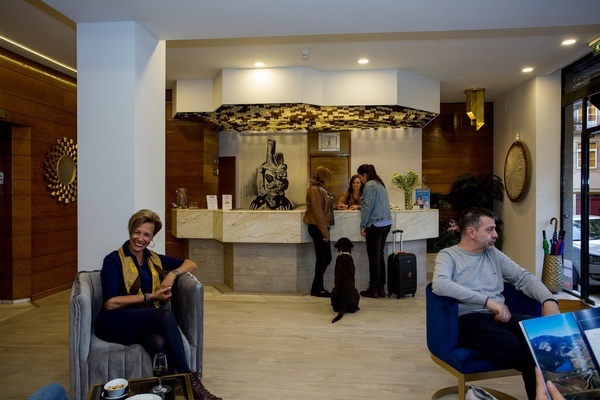 a woman sits in a chair in front of a reception desk