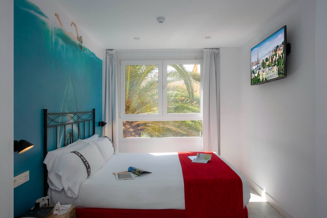Gemütliches Schlafzimmer im Casual del Mar Málaga mit Meerblick und Stadtpanorama-TV.