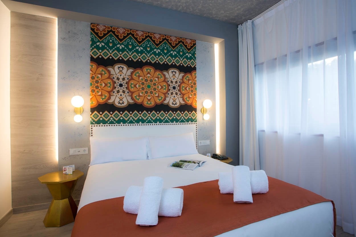 Modernes Hotelzimmer in Porto mit bunten Akzenten und gemütlichem Bett. Zentral gelegen – Casual Inca Porto – Zentrales Hotel in Porto | Casual Hoteles.
