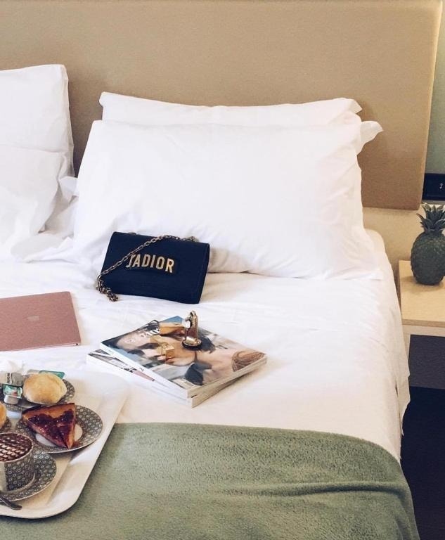 a black purse with the word jadior on it sits on a bed