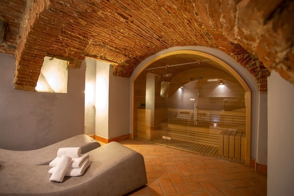 a sauna with a glass door and a brick ceiling