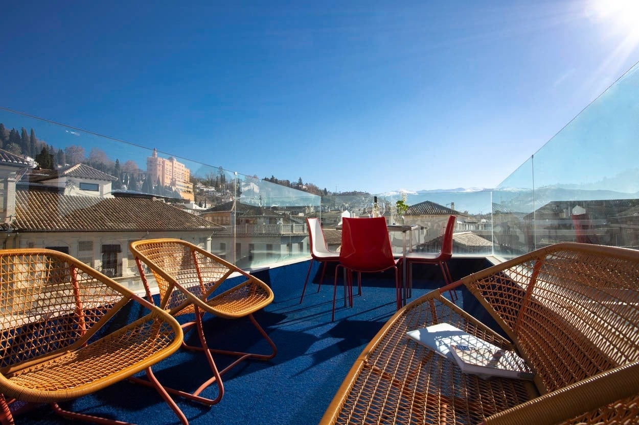 Terraza con vistas, sillas y mesa en Casual Ilbira Granada - Hotel boutique.