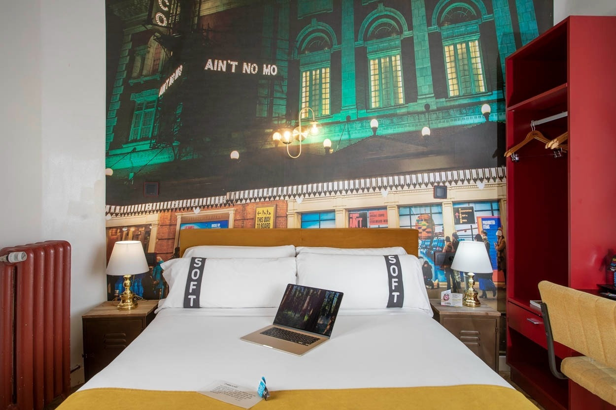 Gemütliches Hotelzimmer im Casual del Teatro Madrid mit Stadtbild-Wandgemälde, Bett und Laptop, Boutique-Hotel nahe der Gran Vía.