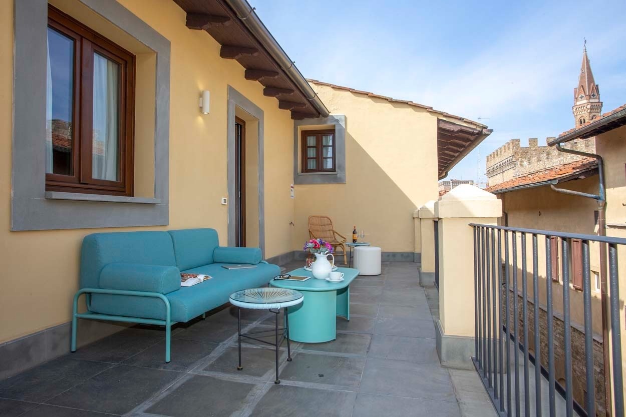 Entspannende Dachterrasse des Casual Rinascimento Firenze - Zentrales Hotel mit Pool in Florenz, mit bequemer Couch und Tischen.