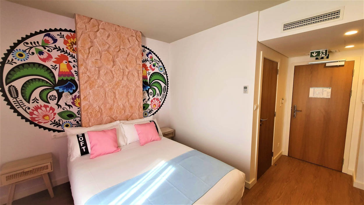 Camera accogliente al Casual Raízes Porto, con vivaci decorazioni a tema gallo e letto comodo. Vicino a Santa Catarina.