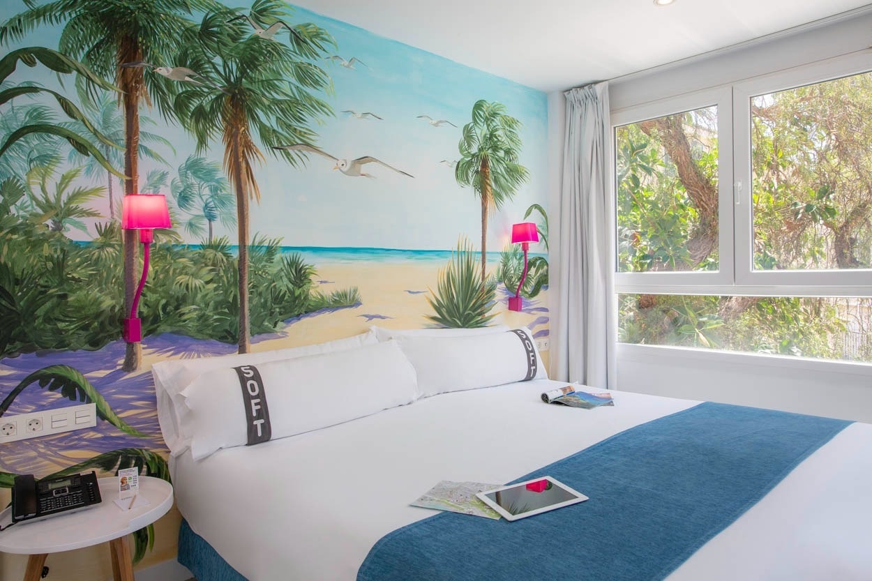 Gemütliches Hotelzimmer mit tropischem Wandgemälde und Meerblick, ideal für Ihren Aufenthalt im Casual del Mar Málaga.