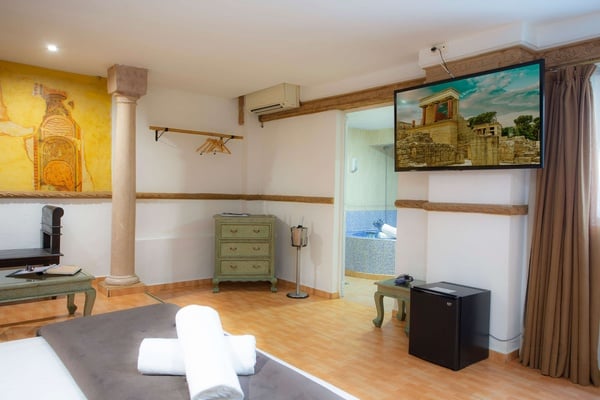 una habitación con una cama y una televisión en la pared