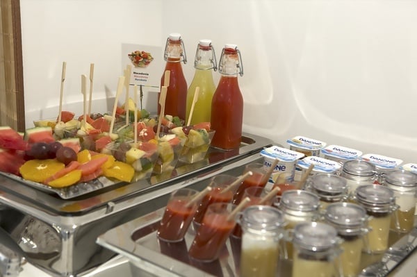 uma bandeja de frutas e bebidas com garrafas de danone