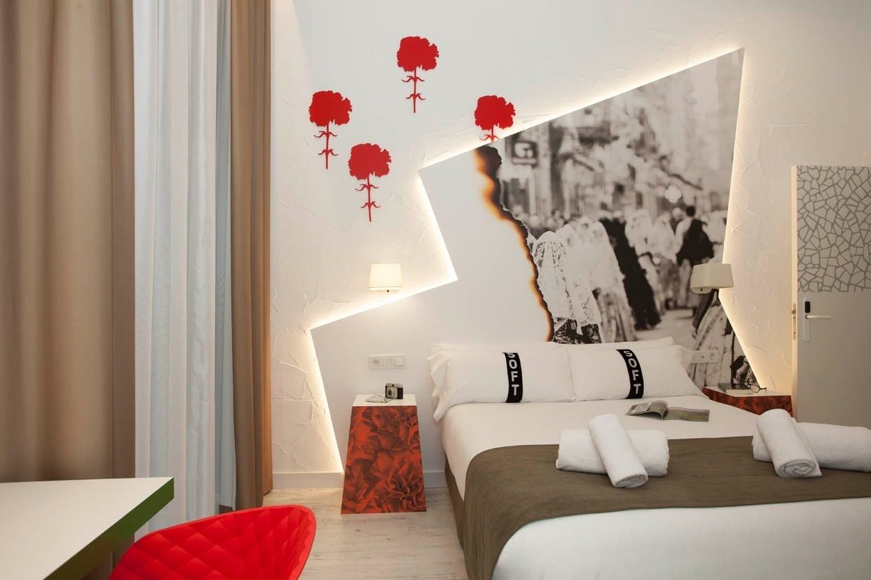 Habitación temática en Casual Socarrat Valencia con mural de flores rojas y foto urbana.