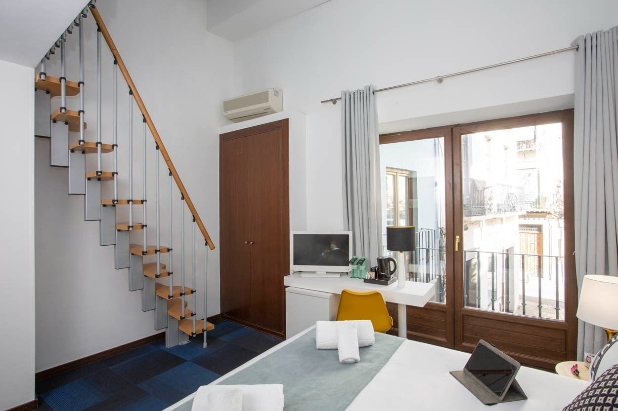 Escalera moderna y escritorio en habitación de Casual Ilbira Granada - Hotel boutique.