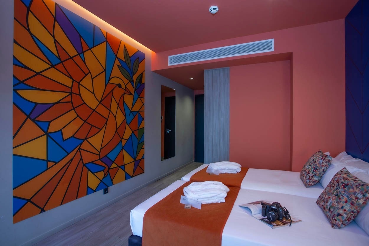 Moderne Zimmer im Casual Kubic Athens: Zwei Betten, Kunstwerk und stilvolle Einrichtung.