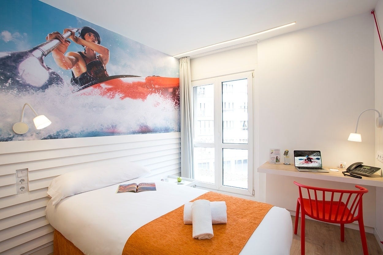 Modernes Hotelzimmer mit Kajak-Motiv-Wandbild und Schreibtisch – Casual de las Olas San Sebastián