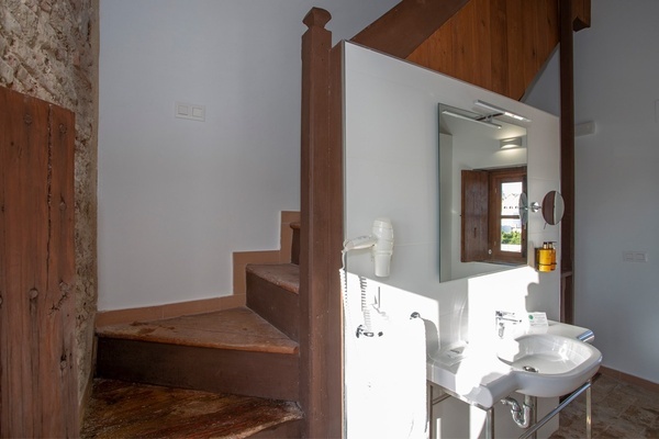 a bathroom with stairs and a sink and a mirror