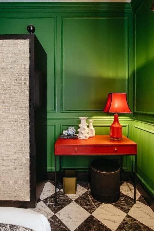 a room with green walls and a red desk with a lamp on it