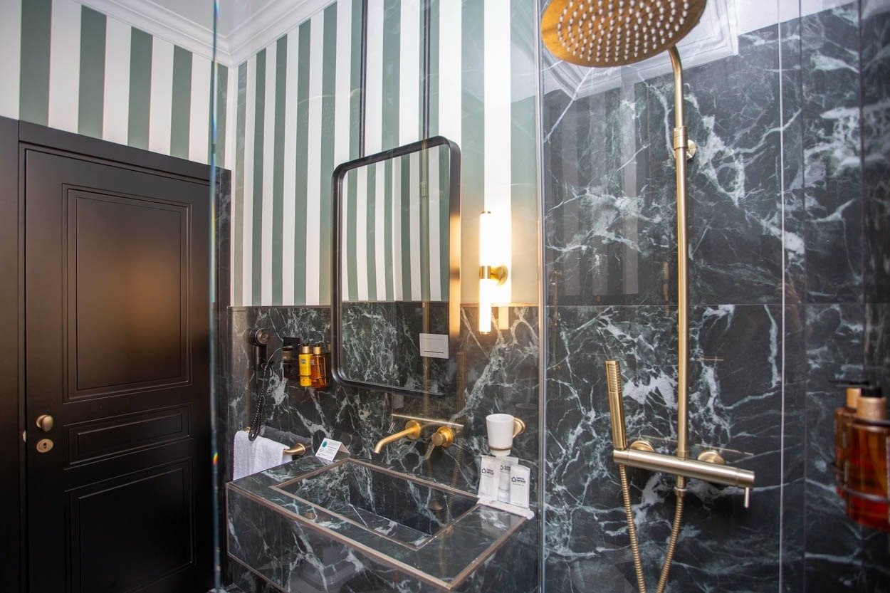 Modernes Bad mit Marmor und Messingarmaturen im Casual Eclettico Milano – Hotel Mailand Nähe Bahnhof Centrale.