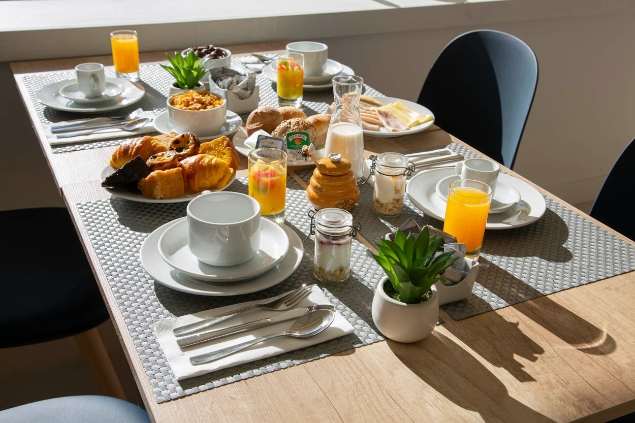 Colazione completa al Casual Raízes Porto - Boutique hotel vicino a Santa Catarina: dolci, succhi, cereali e caffè.